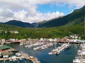 High angle view of boats moored at harbor against mountains and sky