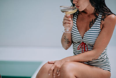 Midsection of a woman drinking glass