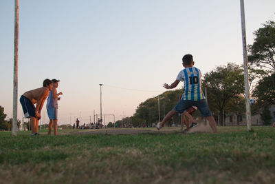 Boy playing on field against sky