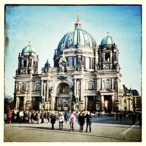 Tourists in front of church against sky