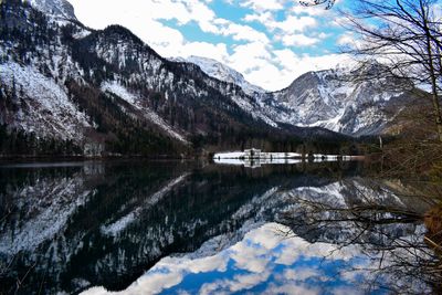 Scenic view of lake by snowcapped mountains against sky