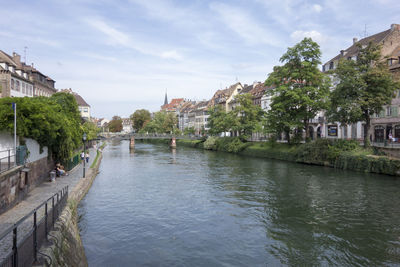 River amidst buildings in city against sky