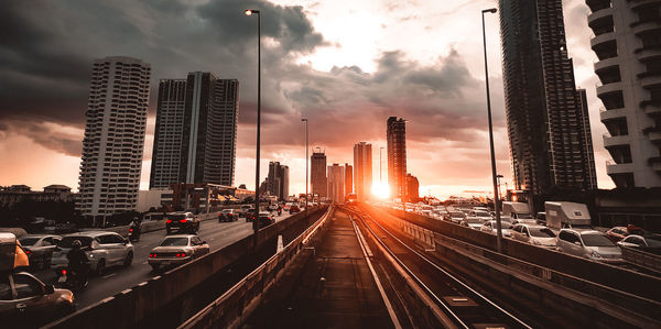 Panoramic view of road amidst buildings against sky during sunset