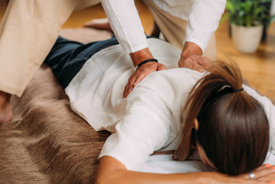 Woman enjoying shiatsu back massage, lying on the shiatsu massage mat.