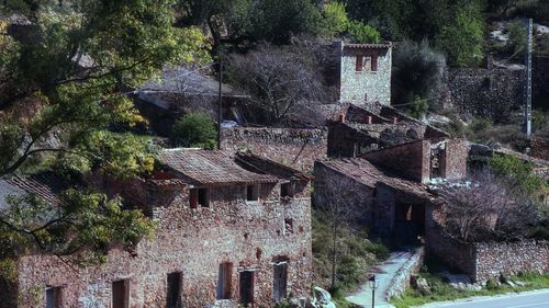 Old house amidst trees and buildings