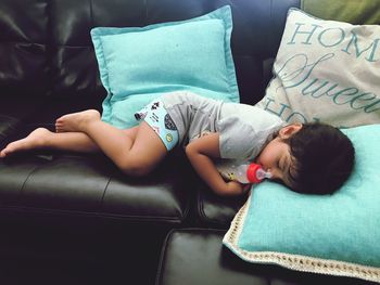 Boy lying on sofa at home