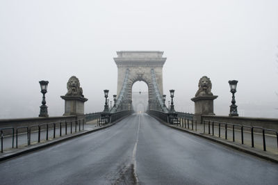 Statue of lions on szechenyi chain bridge against sky