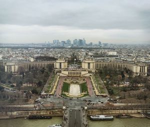 High angle view of city buildings against cloudy sky