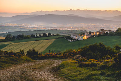 Scenic view of agricultural field against sky during sunset