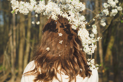 Young beautiful woman among flowering trees. back view. spring concept