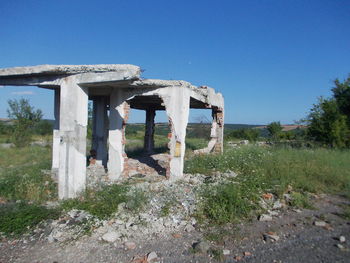 Built structure on field against clear blue sky