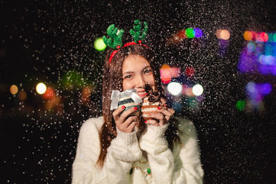 Portrait of teenage girl holding ice during night