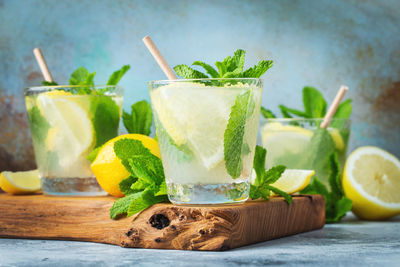 Two glass with lemonade or mojito cocktail with lemon and mint, cold refreshing drink.