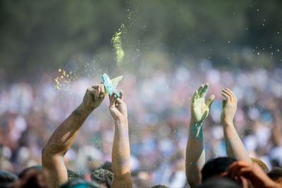 People with arms raised during holi