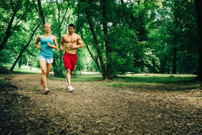 Full length of shirtless man in forest