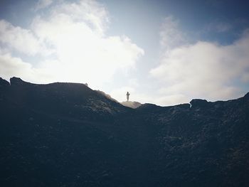 Silhouette of mountain against cloudy sky
