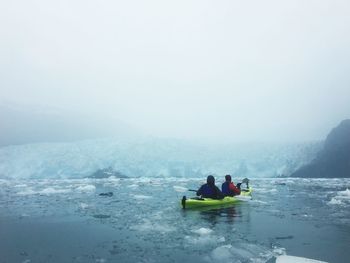 People enjoying in sea against sky