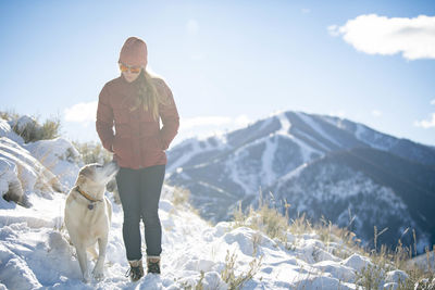 A woman and her lab on a walk on a beautiful winter morning.