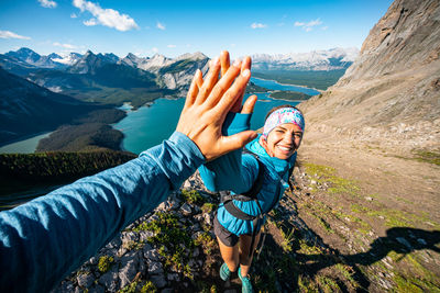 Portrait of happy friends on mountain against sky