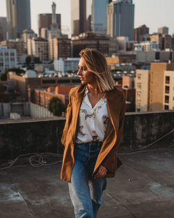 Full length of woman standing against buildings in city