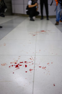 Low section of people standing on tiled floor