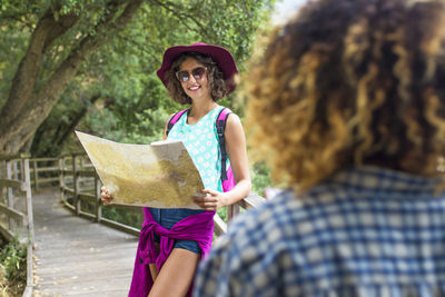 Young friends of tour and travel with holiday map
