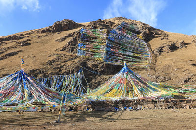 Multi colored umbrellas on mountain against sky