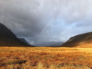 Scenic view of landscape against storm clouds