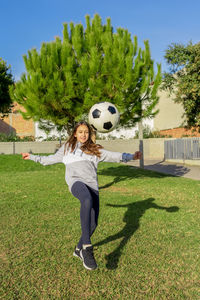 Full length of woman playing soccer on field