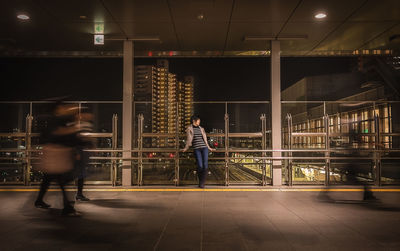 Blurred motion of people walking on illuminated city at night