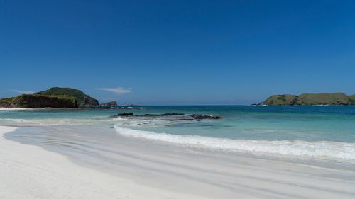 Scenic view of beach against blue sky