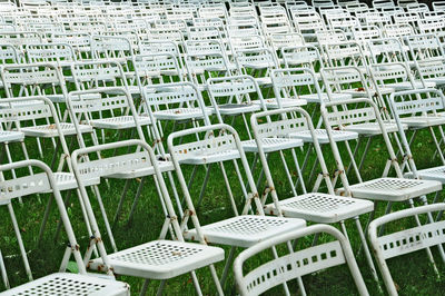 Full frame shot of empty chairs arranged on grassy field