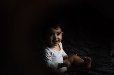 Baby smiling in bed with sunset light