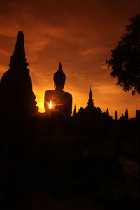 Silhouette statue of building against sky during sunset