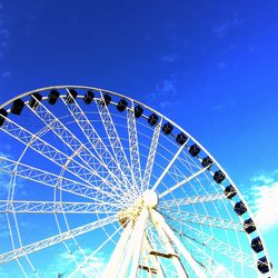 Low angle view of ferris wheel against blue sky