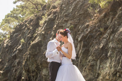 Rear view of couple holding umbrella