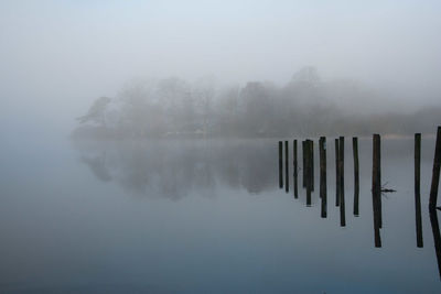 Scenic view of lake against sky during foggy weather