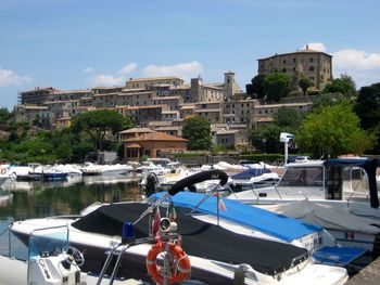 Boats moored in city against clear blue sky