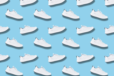 White sneakers seamless pattern on blue background