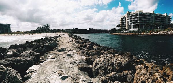 Scenic view of seawall against cloudy sky