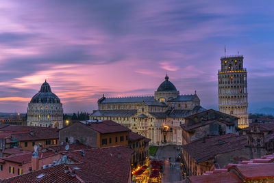 Buildings in city against sky during sunset