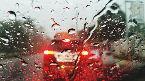 Close-up of car seen through raindrops on windshield