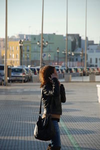 Woman walking on footpath in city