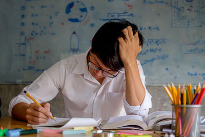 Midsection of man reading book on table