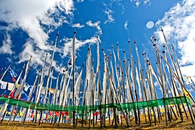 Low angle view of poles on beach against blue sky