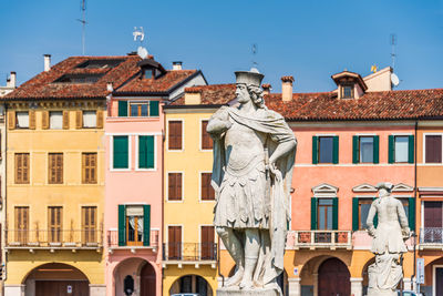 Statue against buildings in city of padua against clear sky