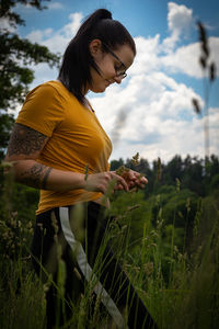 Woman standing on field against sky