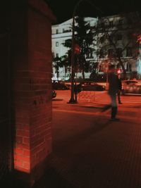 Full length of woman standing in illuminated city at night