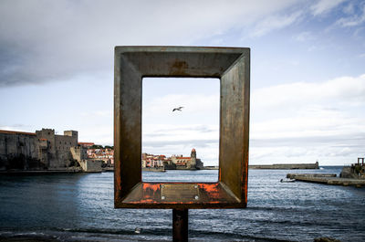 Sculpture by sea against sky