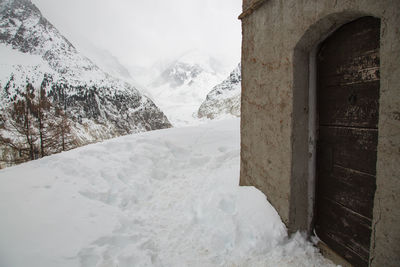 Snow covered mountain against buildings